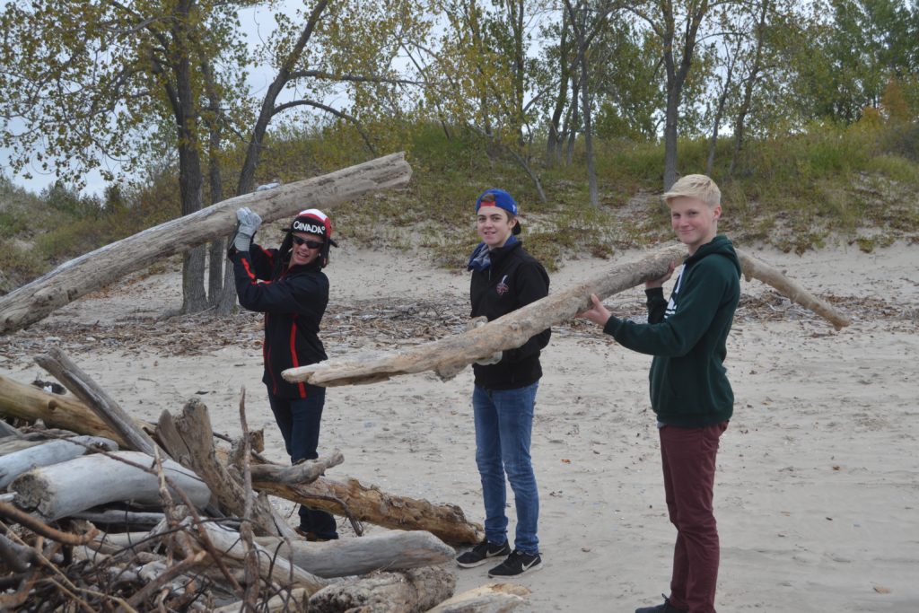 <p>PECI Venture Students (From Left) Thomas Davies, Nolan Steen and Max Lindsay clean up drift wood at Sandbanks Provincial Park Friday. (Jason Parks/Gazette staff)</p>
