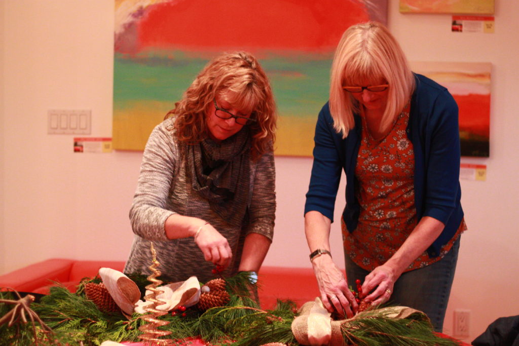 <p>Cathy Mark and Rita Rickard make some wreaths during Wassail at Sandbanks Winery on Saturday afternoon. Wassail continues at local wineries on Nov. 25–26 and Dec. 2–3 (Chad Ibbotson/Gazette staff)</p>
