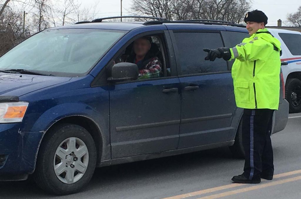 <p>Visibility – Prince Edward County OPP detachment commander Staff Sgt. John Hatch waves a driver through a RIDE check on Hwy 62 in Rossmore Thursday.  The check marked the launch of the Quinte Region Traffic Coalition’s Festive RIDE campaign. (Adam Bramburger/Gazette staff)</p>

