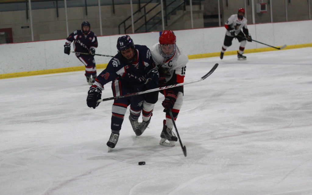 <p>Port Hope’s Nathan Snoek battles with Pirate Jordon Cannons for a loose puck during Picton’s 4–1 win last Thursday. (Chad Ibbotson/Gazette staff)</p>
