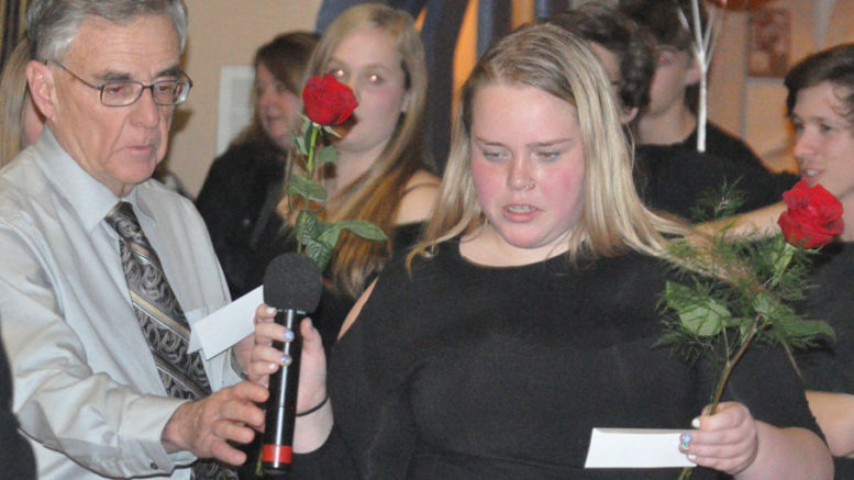 <p>Honouring women – Frank Wright and Ruby Gaudett take turns reading off the names of victims of violence against women before placing roses in their honour during Alternatives For Women’s annual Dec. 6 candlelight vigil at  St. Andrew’s Presbyterian Church. More people attended this year than last.(Adam Bramburger/Gazette staff)</p>
