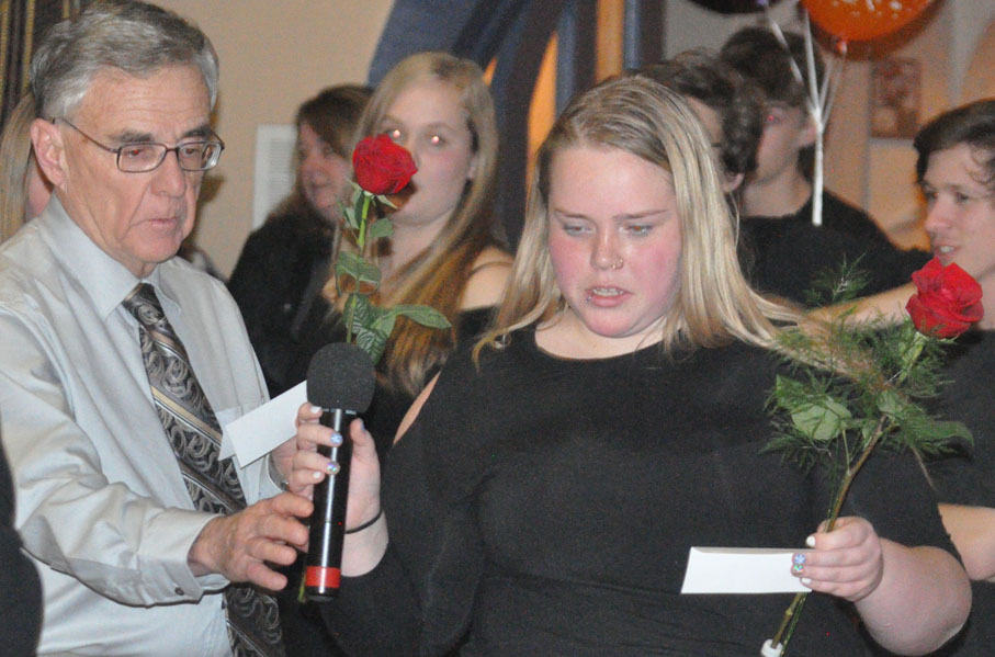 <p>Honouring women – Frank Wright and Ruby Gaudett take turns reading off the names of victims of violence against women before placing roses in their honour during Alternatives For Women’s annual Dec. 6 candlelight vigil at  St. Andrew’s Presbyterian Church. More people attended this year than last.(Adam Bramburger/Gazette staff)</p>
