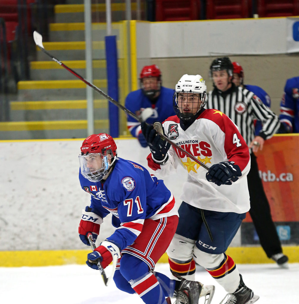 <p>BATTLE OF THE BLADES- Zach Anderson of the Oakville Blades slips past Eric Uba of the Wellington Dukes Sunday at Essroc Arena. Wellington lost at home for the first time since October. (Gazette photo)</p>

