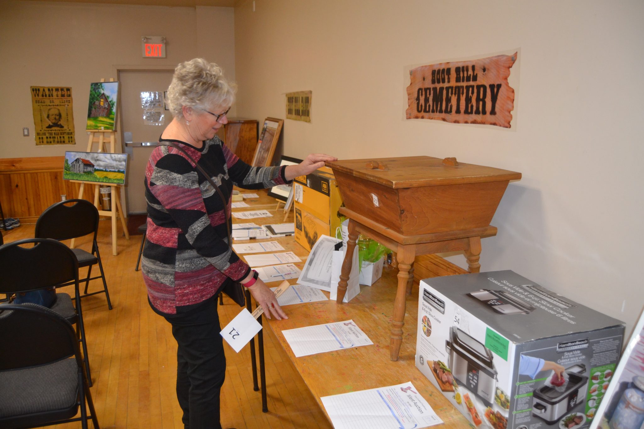 <p>ALL FOR DRIES- Picton&#8217;s Deb Hepburn examines one of the items up for auction at a recent fundraising event for Dries Lombard. (Jason Parks/Gazette Staff)</p>
