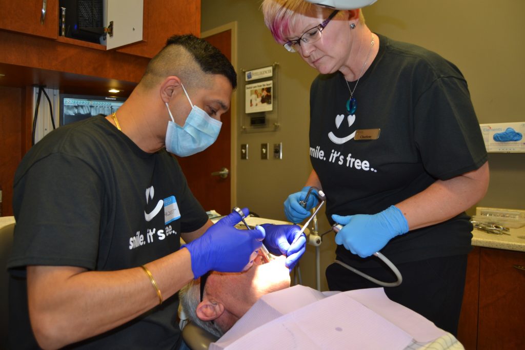 <p>CARE FROM THE HEART- Dr. Kuldeep Sandhu and hygienist Charlene Cruickshank examine a patient at the 2018 Dentistry From the Heart event on Friday. (Jason Parks/Gazette Staff)</p>
