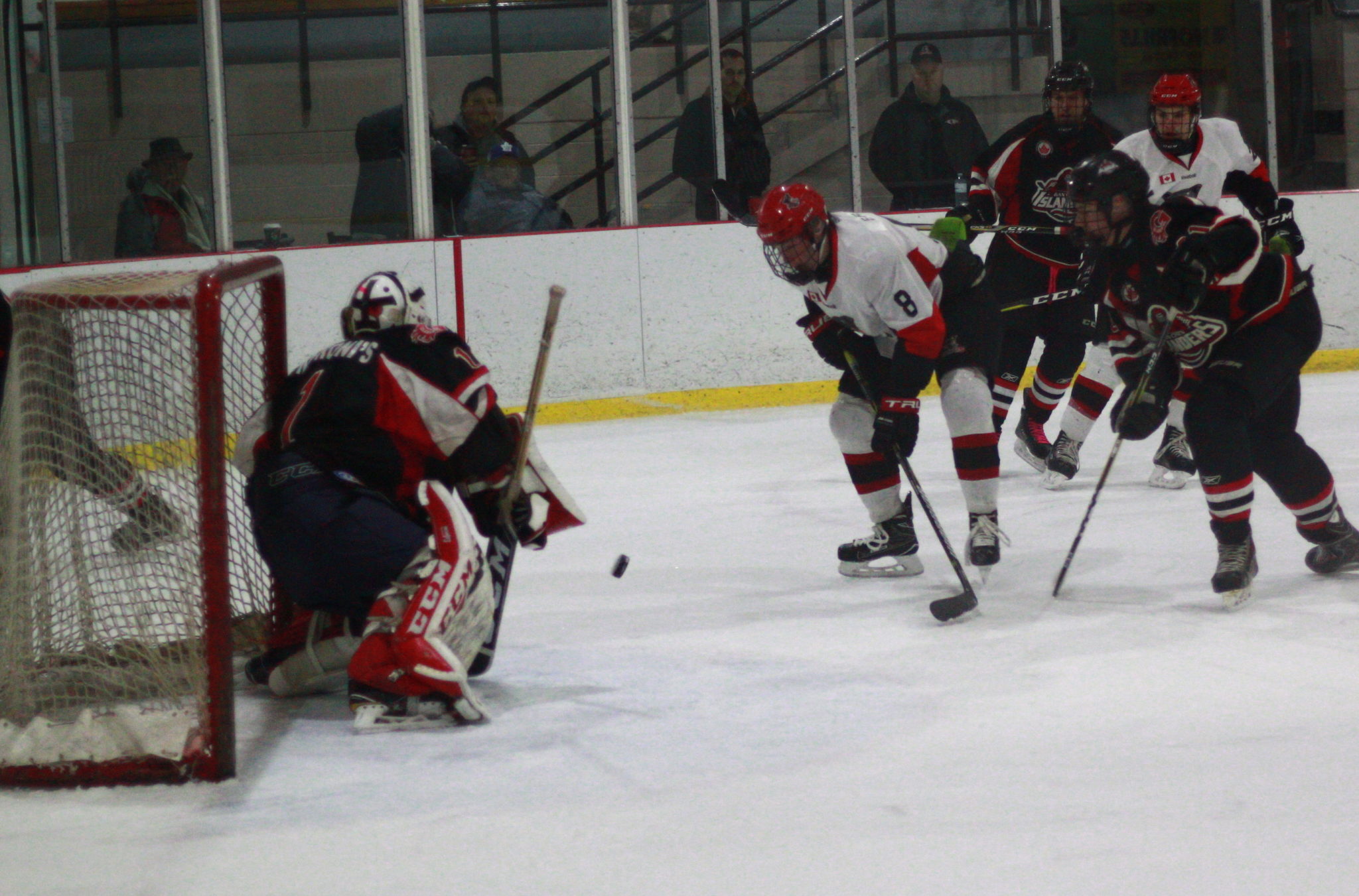 <p>Pirates forward Noah Brant tracks a bouncing puck with Islanders goaltender Josh Rowden looking on. (Chad Ibbotson/Gazette staff)</p>
