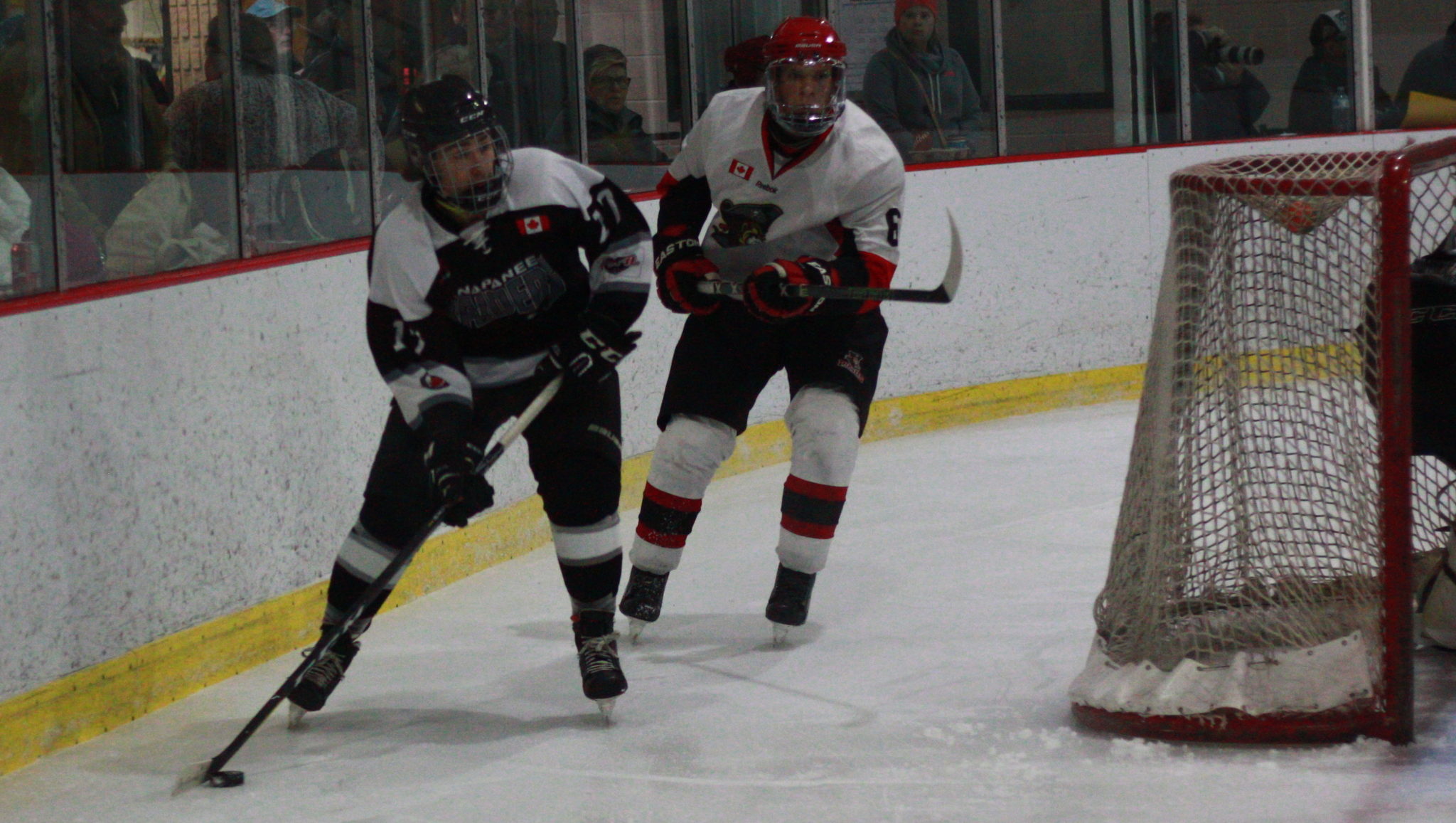 <p>Napanee&#8217;s Cullen Hinds collects the puck behind his own goal with Picton forward Nick Hoey a step behind during a Nov. 16 clash versus the Raiders. (Gazette file photo)</p>
