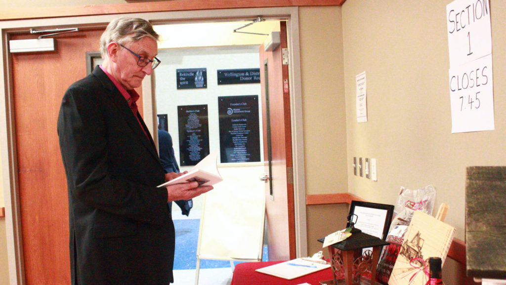 <p>David Middleton peruses some of the items available during the silent auction at Hospice Prince Edward’s gala dinner on Saturday evening. (Chad Ibbotson/Gazette staff)</p>
