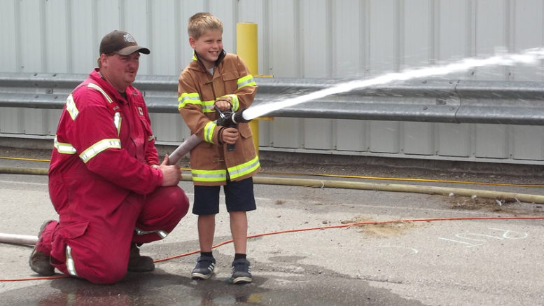 <p>The real thing – With some help from firefighter Mark Gilbert, 8-year-old Braden Nyman of Carrying Place     handled a real fire hose during Saturday’s challenge event in Wellington. (Terry McNamee/For The Gazette)</p>
