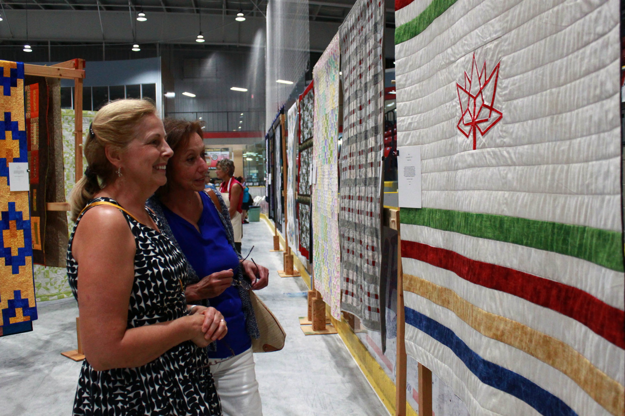 <p>Marie Newman and Susan Petroff explore some quilts at the Wellington and District Community Centre on Saturday. (Chad Ibbotson/Gazette staff)</p>
