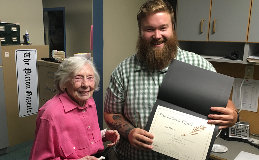 <p>Moving on – Gazette publisher Jean Morrison presents reporter Chad Ibbotson with a Bronze Quill Award from the Ontario Community Newspapers Association in honour of his nine years of service to Prince Edward County readers. Ibbotson is leaving the newspaper to return to school this fall. (Adam Bramburger/Gazette staff)</p>
