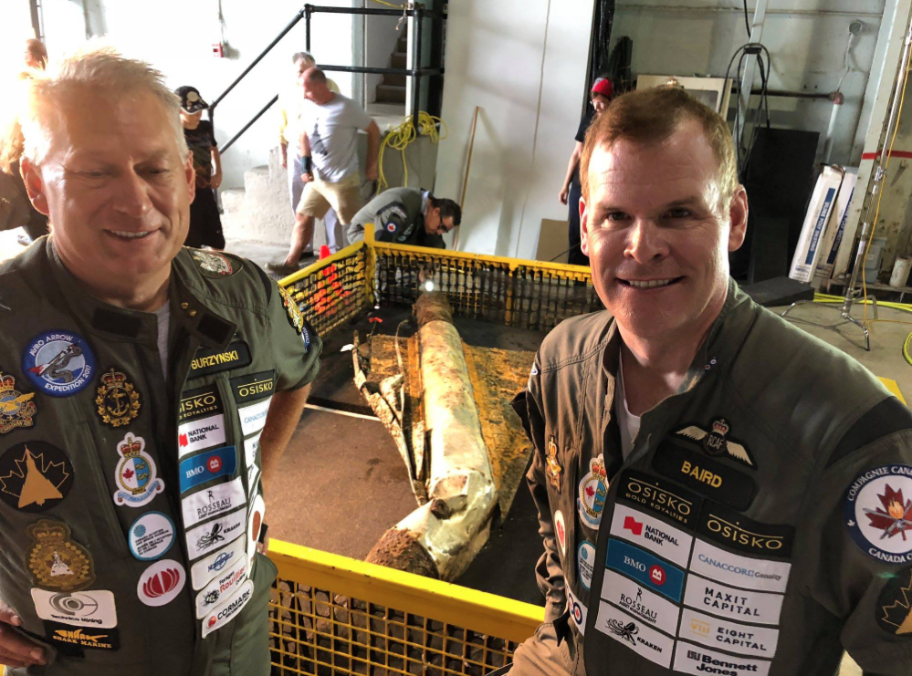 <p>IMPORTANT DISCOVERY- (From Left) Raise the Arrow project leader John Burzynski and former Canadian Foreign Affairs Minister John Baird stand with a recovered delta wing test vehicle at 8 Wing in Trenton last week. (Raise the Arrow photo)</p>
