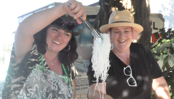 <p>Food to offer – Susanne Larner, left, and Krista Dalby serve noodles during the original Feast! in 2016. Food Not Bombs plans to bring a similar event back to Benson Park this Sunday. (Adam Bramburger/Gazette staff)</p>
