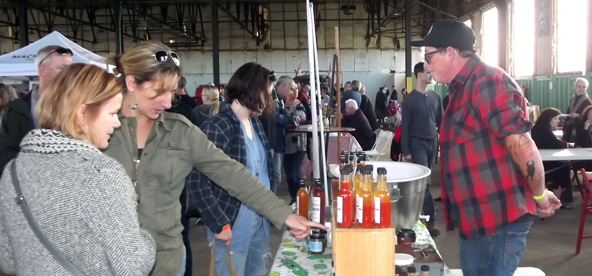 <p>Meet the producer &#8211; Pyramid Ferments co-owner Alex Currie, right, was busy answering questions and talking about his company&#8217;s handcrafted, raw, live and fermented sauerkraut, kimchi and kombucha. (Terry McNamee/For The Gazette)</p>
