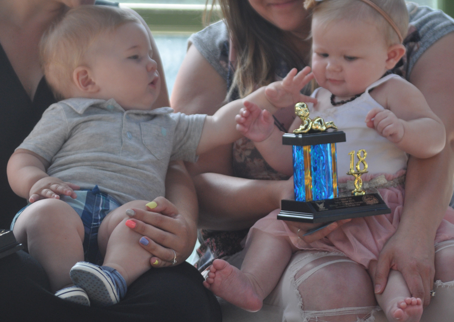 <p>Prized pair – Picton Fair baby show winner Tyler Jeffery Mulder, left, and runner-up Iyla Grace Anne Stefankiewicz share a moment during the final round of judging at the Crystal Palace Friday. (Adam Bramburger/Gazette staff)</p>
