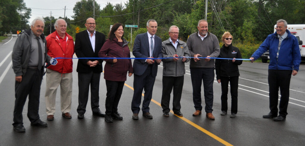 <p>Ribbon on road – From left, Roy Pennell, Barry Turpin, Steve Ferguson, Janice Maynard, Neil Ellis, Robert Quaiff, Todd Smith, Dianne O’Brien, and James Hepburn celebrate the completion of road reconstruction on County Rd. 3 in Rossmore Monday. (Adam Bramburger/Gazette staff) </p>
