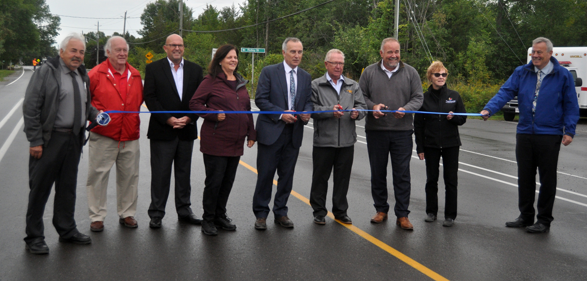 <p>Ribbon on road &#8211; From left, Roy Pennell, Barry Turpin, Steve Ferguson, Janice Maynard, Neil Ellis, Robert Quaiff, Todd Smith, Dianne O&#8217;Brien, and James Hepburn celebrate the completion of road reconstruction on County Rd. 3 in Rossmore Monday. (Adam Bramburger/Gazette staff) </p>
