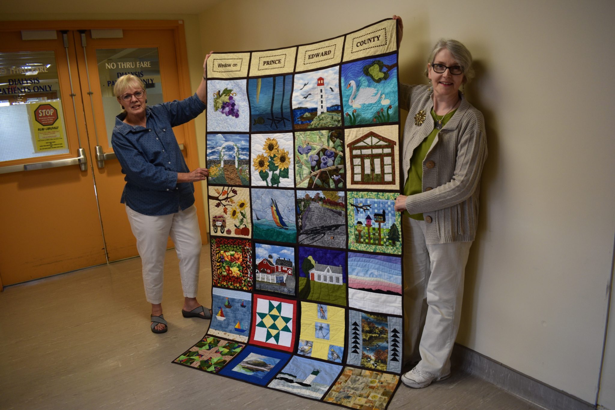 <p>WARM, HOMEY FEELING- (From left) Prince Edward County Quilter’s Guild members Nancy Hicks and Janet Reader Day hold up a county-themed quilt created by Guild members and presented to the Prince Edward County Memorial Hospital for display in the local frontline healthcare facility. (Jason Parks/Gazette Staff)</p>
