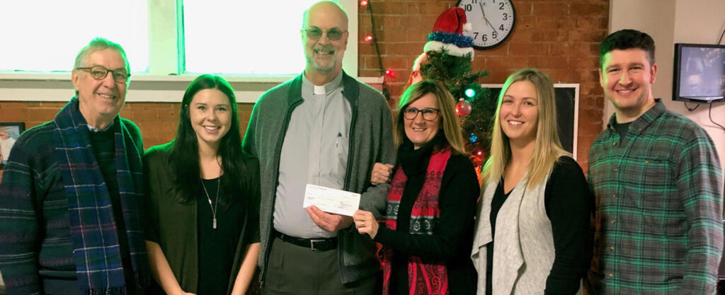 <p>St. Mary Magdalene Anglican Church archdeacon Charles Morris presented the Recreation Outreach Centre (ROC) staff with a $2,500 cheque, which provides enough money to operate its Prince Edward County Youth Centre for one month. The cheque came from the proceeds of the church’s annual Christmas Tea and Bake Sale. Joining Morris (third from left) are, from left:  Michael Smith (ROC vice-chair) , Sydney Kerr, Darlene Thompson (ROC executive director), Lindsay Ferguson, and Ben Wadsworth.  The church is hoping its donation will encourage other businesses and organizations in the community to also commit to funding a month of the centre’s operations this year.  (Submitted photo)</p>
