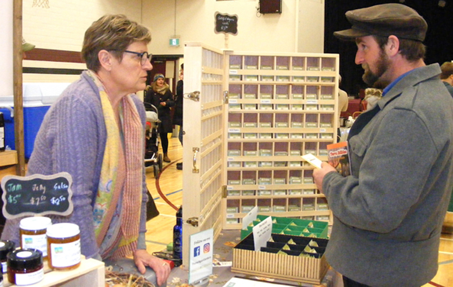 <p>Planting seeds – Lorraine Schmid of Carrying Place represented her Thyme Again Gardens during Seedy Saturday at PECI on Saturday. Here she is chatting with Warkworth resident and mushroom grower Derik Greenly. More than 30 vendors participated. (Terry McNamee/For The Gazette)</p>
