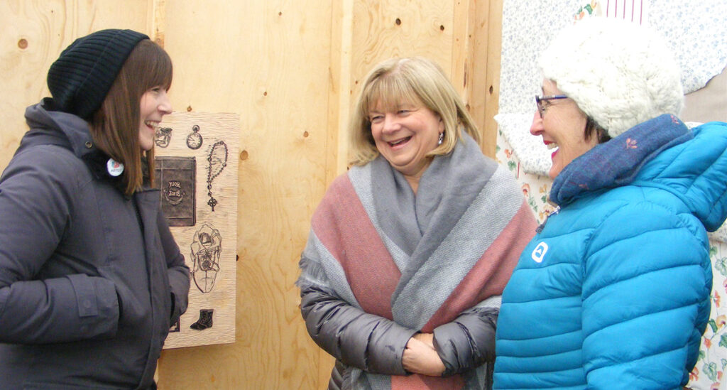 <p>Associating through art – Printmaker Chrissy Poitras (left) of Picton’s Spark Box Studio, chats with visitors Mary Camp (middle) and Shirley Allan, both of East Lake, during opening day of Ice Box in Macaulay Heritage Park in Picton on Saturday. (Terry McNamee/For The Gazette)</p>
