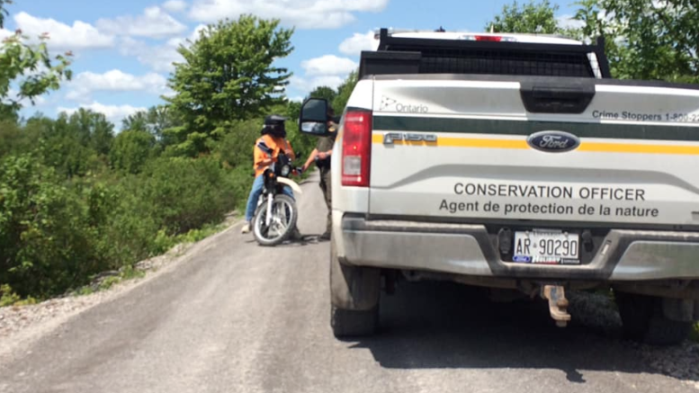 <p>TALKING ON THE TRAIL- A Conservation Officer with the Ministry of Natural Resources and Forestry speaks with a person on a dirt bike on Sunday. (Facebook Photo)</p>
