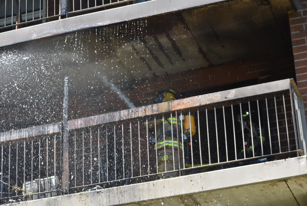 <p>A Prince Edward County Firefighter douse a third floor fire at an apartment complex in south west Picton on Saturday afternoon. (Jason Parks/Gazette Staff)</p>
