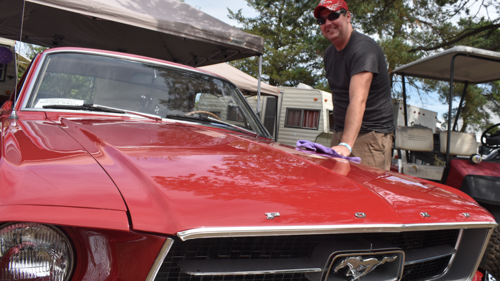<p>SHINE DOWN AT STREET MEET- Odessa’s Sean Truscott shines his classic cherry red Ford Mustang at the 45th annual Prince Edward Auto Club Street Meet on Sunday. (Jason Parks/Gazette Staff)</p>
