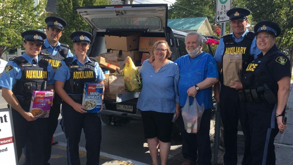 <p>RECORD SETTING DAY- (From Left) Prince Edward OPP Auxiliaries Matthew Lourenco, Matthew Brinklow, Lindsay Ferguson,  Wellington Residents Teresa Fischer and Terry Wolfery, Auxiliary Jordan Smart and Community Safety and  Media Relations Officer Constable Karen German at Saturday’s ‘Cram the Cruiser’ event in benefit of Wellington’s Storehouse Foodbank. (Submitted Photo)</p>
