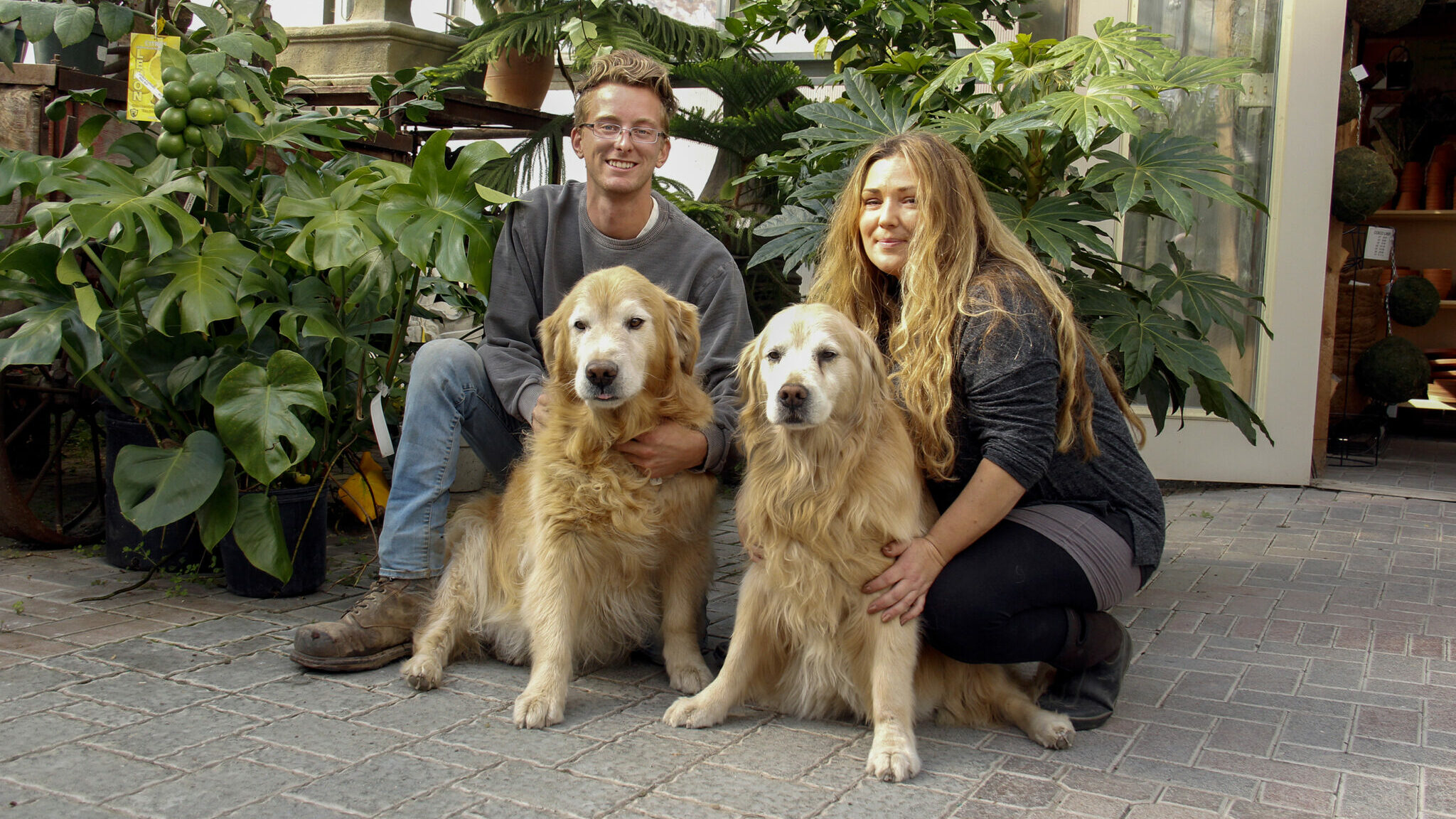 <p>SERVICE WITH A SMILE Tyler Moore, Greg Moore’s nephew and Tanya Mills, an employee at Lockyer’s posed with the store greeters (left) Barkley and (right) Sophie. Lockyer’s Country Gardens celebrated their 100th anniversary of service in Prince Edward County over the weekend. (Desirée Decoste/Gazette Staff)</p>
