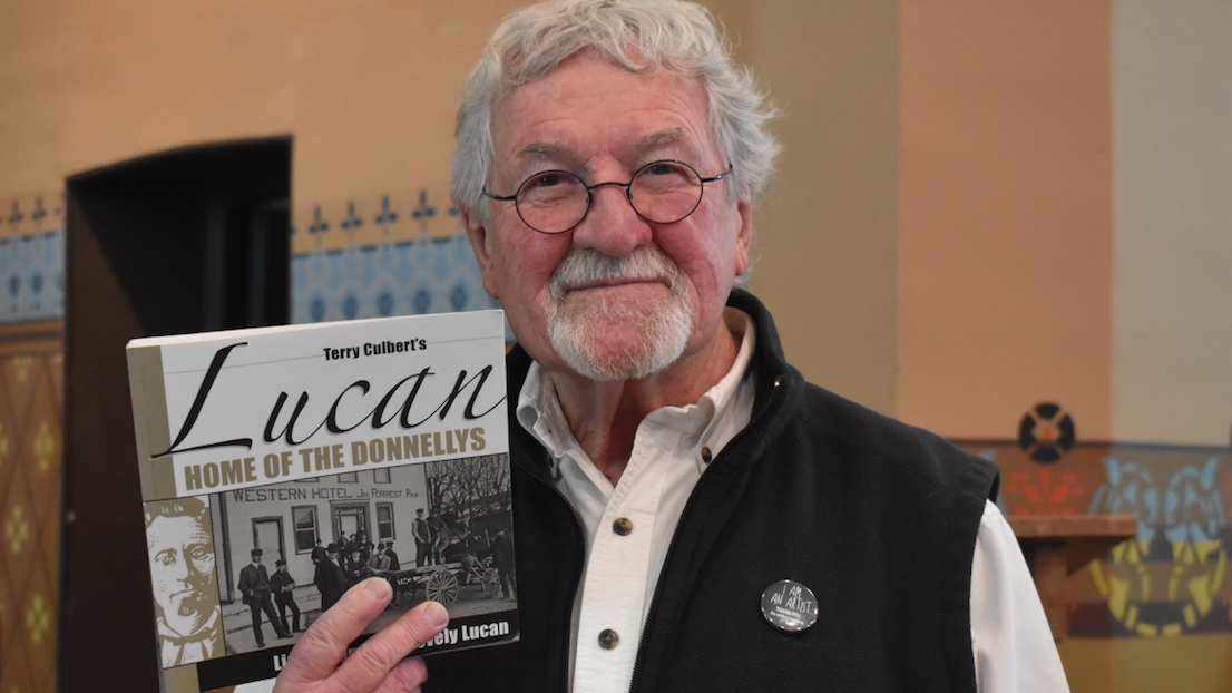 <p>NOW AND THEN: Local author Terry Culbert poses with his book Lucan: Home of the Donnellys, before a talk given as part of Flashback February. (Sarah Williams/Gazette Staff)</p>
