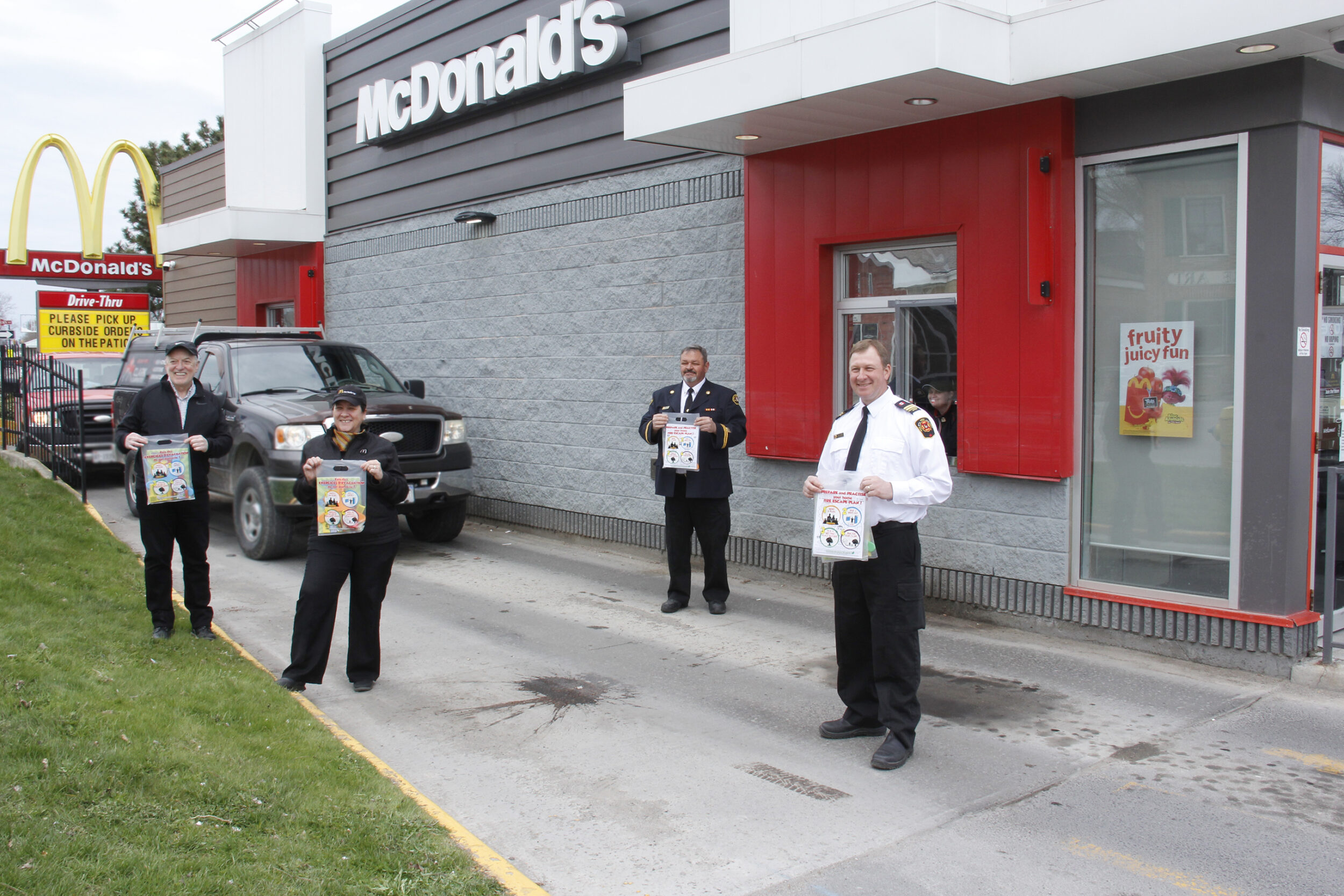 <p>GETTING THE MESSAGE OUT (From left) Owner Dan Doyle,  Assistant Manager Jana Leybourne, County of Prince Edward Fire Prevention Officer Mike Branscombe and fellow Fire Prevention Officer Greg Gorsline in front of the Picton McDonalds drive thru with fire safety education bags McDonalds employees will be handing out on Friday with Happy Meals. (Desirée Decoste/Gazette Staff)</p>
