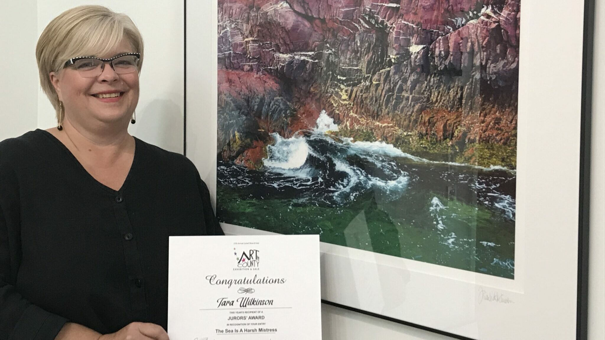 <p>JUROR&#8217;S CHOICE- Tara Wilkinson stands next to her work entitled &#8220;The Sea Is A Harsh Mistress&#8221; which won a Juror&#8217;s Choice Award. (Submitted Photo)</p>
