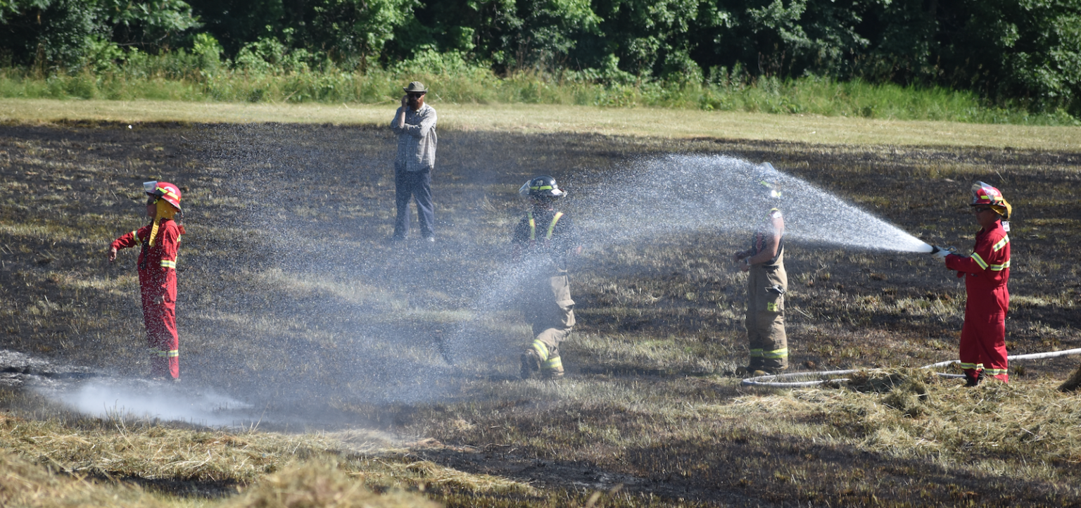 <p>Prince Edward County Fire and Rescue Crews douse a hay field in North Marysburgh on Monday afternoon. (Jason Parks/Gazette Staff)</p>

