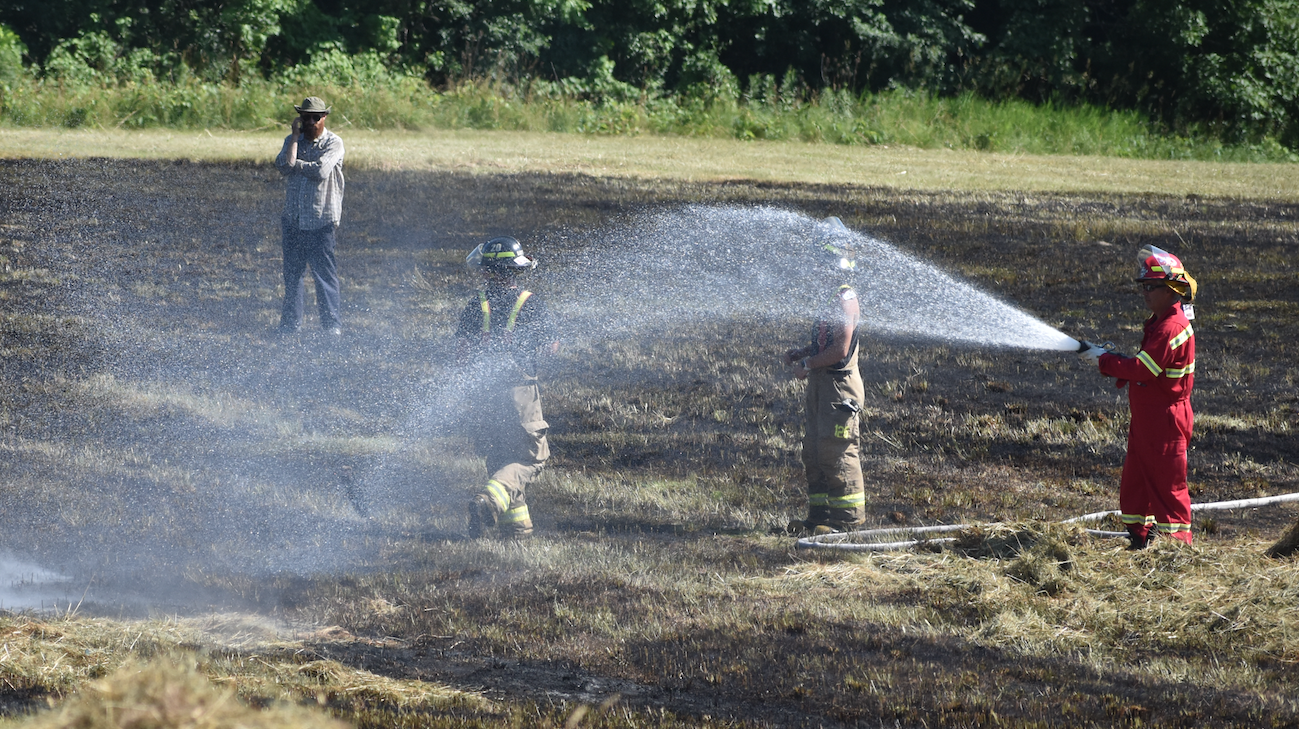 <p>Prince Edward County Fire and Rescue Crews douse a hay field in North Marysburgh on Monday afternoon. (Jason Parks/Gazette Staff)</p>
