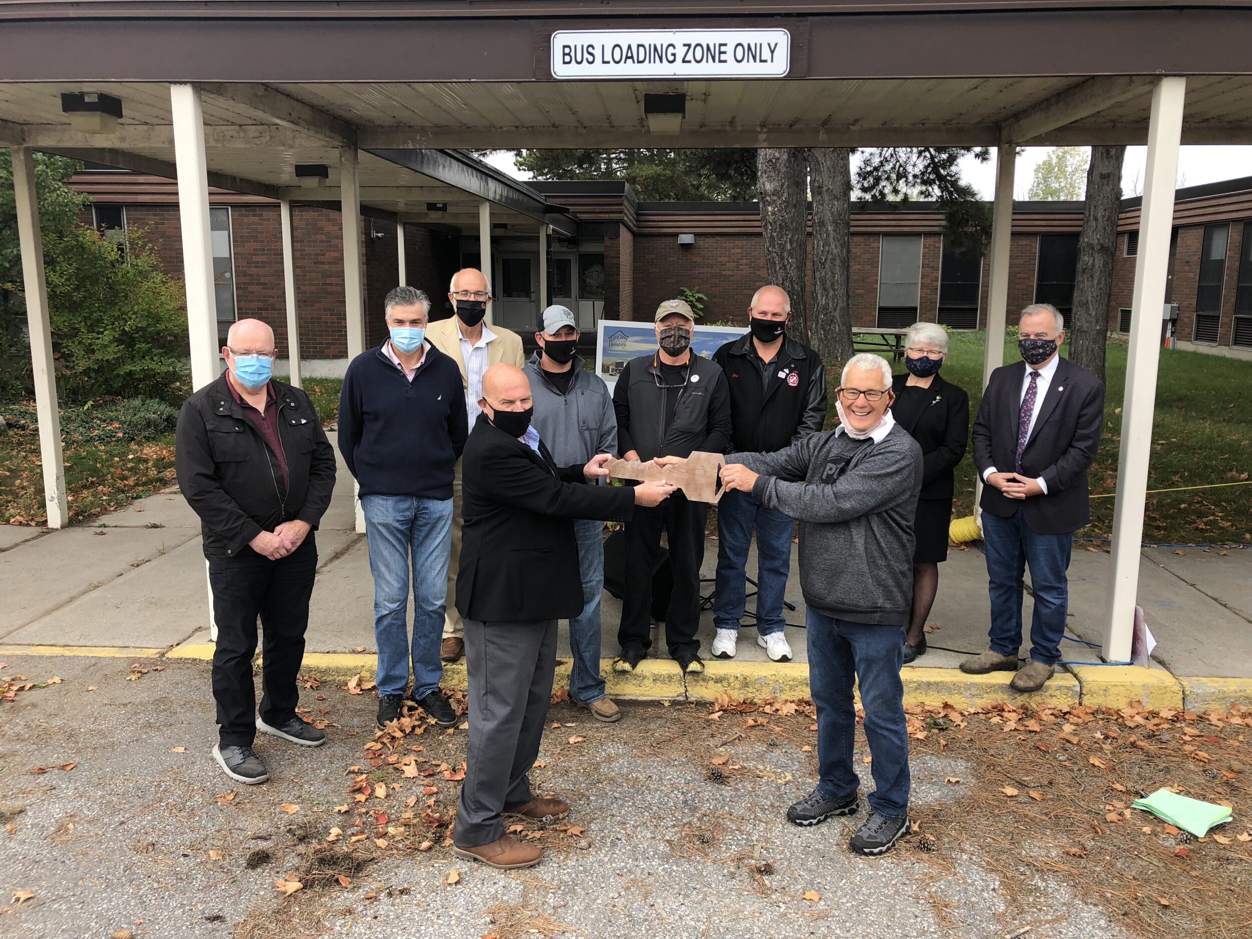 <p>A SONG IN THEIR HEARTS- (Front left) County of Prince Edward Mayor Steve Ferguson turns over a ceremonial key to LoveSong Board Member Ken How as (Back left) Councillors John Hirsch,  Ernie Margetson, David Joyce from MPP Todd Smith’s office, Councillors Phil Prinzen, Bill Roberts and Phil St. Jean, LoveSong’s Donna Rodgers and MP Neil Ellis look on at the former Pinecrest Memorial Elementary School Monday morning. (Jason Parks/Gazette Staff)</p>
