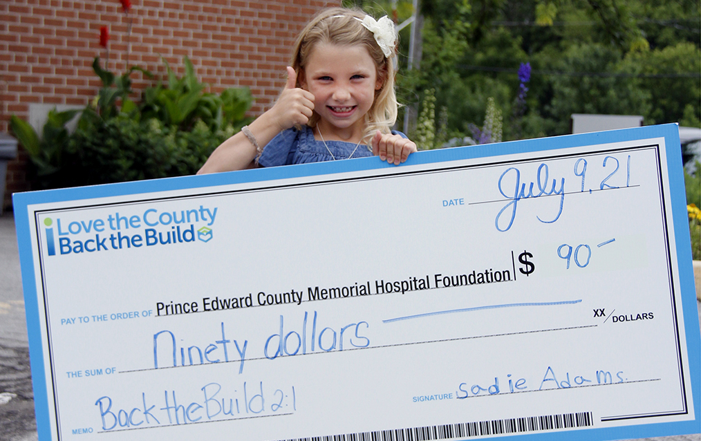 <p>BACKING THE BUILD  Sadie Adams, 7, pictured in front of Prince Edward County Memorial Hospital on Friday. Adams presented her earnings from a yard sale to Back the Build for a new hospital. (Desirée Decoste/Gazette staff)</p>
