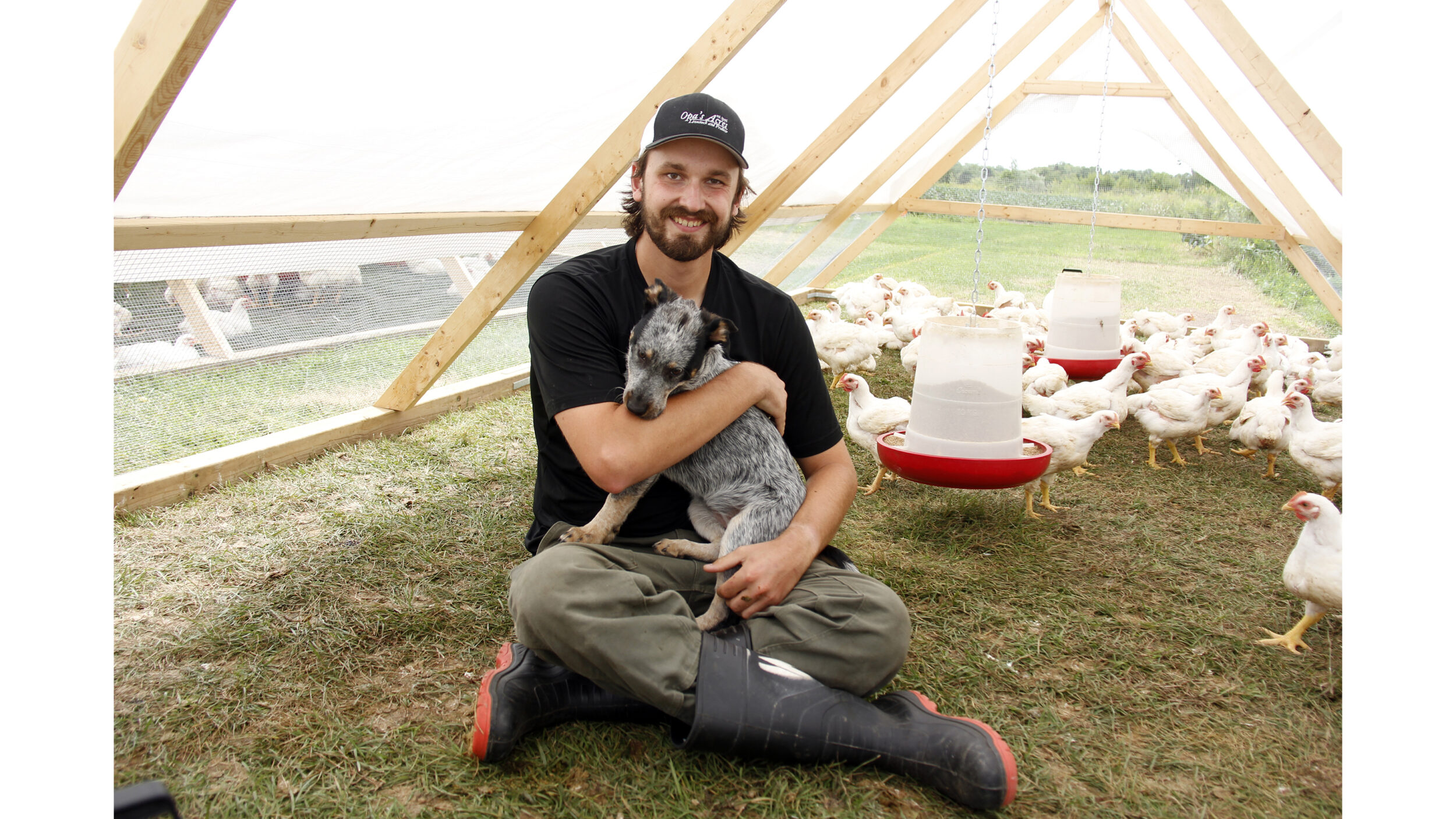 <p>IN THE PEN Third generation farmer Wyatt Brauer sitting in one of his five chicken tractors on his family’s 200 acre farm where he has started a pasture raised chicken business called Opa’s Acres. (Desirée Decoste/Gazette staff)</p>
