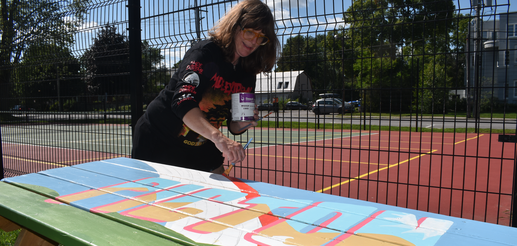 <p>Picton artist Nella Casson applies paint to a picnic table at Benson Park Monday. Casson is one eight local artists involved in a Picton BIA supported initiative to enhance the park’s picnic tables.  (Jason Parks/Gazette Staff)</p>
