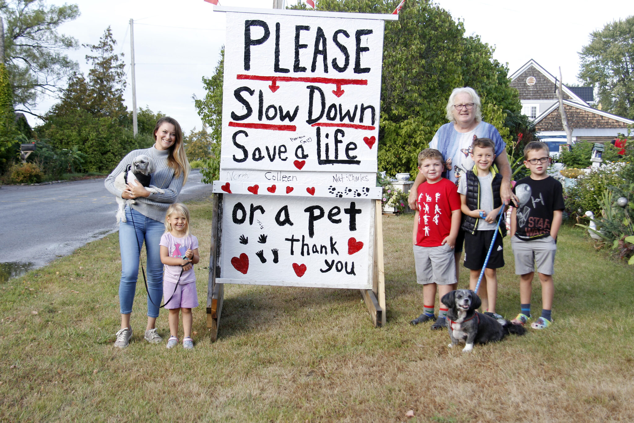 <p>SLOW DOWN Residents of Ridley Street in Rossmore (left) Mihaela Pal, Annaliese Bostock, (back right) Colleen Allchurch, Everest Horrocks, Austen Bostock and Maverick Horrocks stood with the 4×6 foot slowdown sign that Allchurch and her husband created for the street. (Desirée Decoste/Gazette staff)</p>
