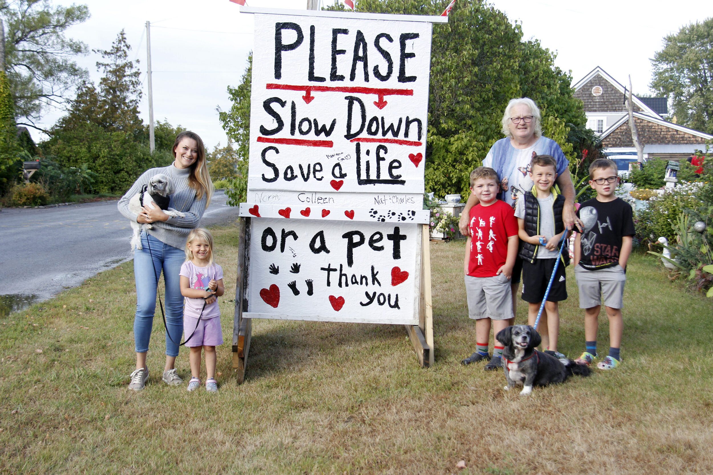 <p>SLOW DOWN Residents of Ridley Street in Rossmore (left) Mihaela Pal, Annaliese Bostock, (back right) Colleen Allchurch, Everest Horrocks, Austen Bostock and Maverick Horrocks stood with the 4×6 foot slowdown sign that Allchurch and her husband created for the street. (Desirée Decoste/Gazette staff)</p>
