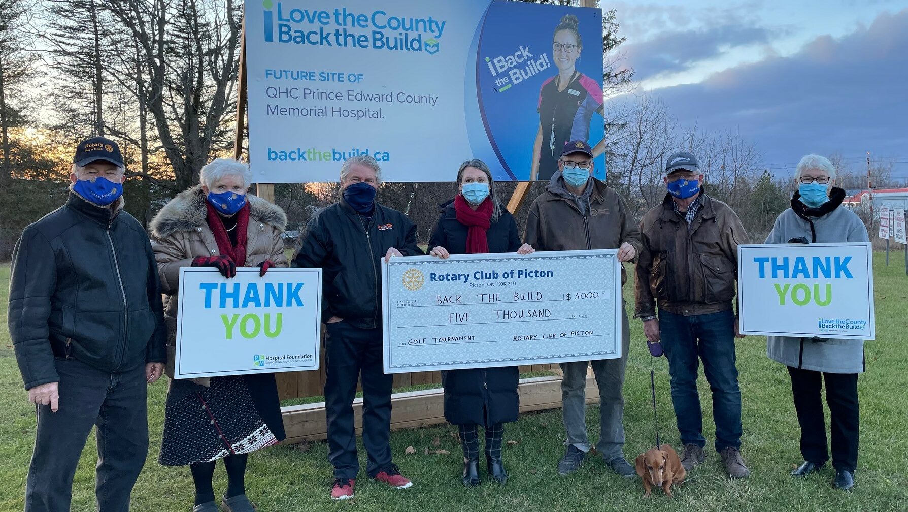 <p>Pictured in front of the Back the Build billboard behind QHC PECMH from left: Libby Crombie, Rotarian and Back the Build campaign cabinet member; Rick Jones, Rotarian; JJ Johnston, Rotarian and chairperson of the Rotary Club of Picton’s golf tournament; Shannon Coull, Rotarian and Executive Director of the PECMH Foundation, Dan Wight, President of the Rotary Club of Picton; Maurice Carlier, treasurer of the Rotary Club of Picton with his dog, Toby; and Sally Cowan, Back the Build campaign cabinet member. (Photo by Sue Vincent)</p>
