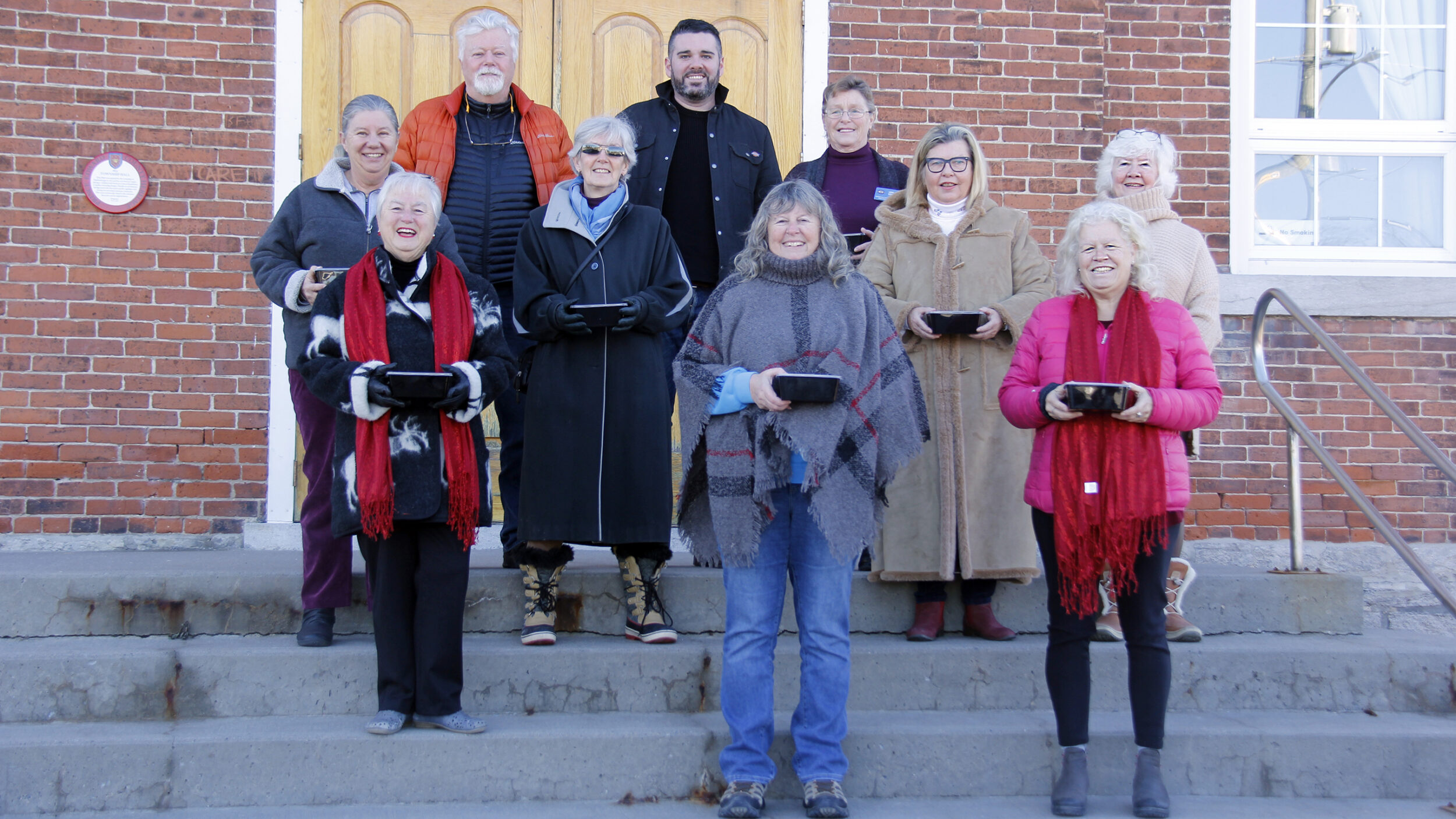 <p>1,000 TIMES OVER The Demorestville Women’s Institute with Chef Taylor McIndless, prepared and distributed approximately 1,000 meals within the county in 2021. Pictured in front of the Demorestville Town Hall are (back left) Councillor Bill Roberts, Chef Taylor McIndless, members of the Demorestville Women’s Institute and members of the community who helped with the meal deliveries. (Desirée Decoste/Gazette staff)</p>
