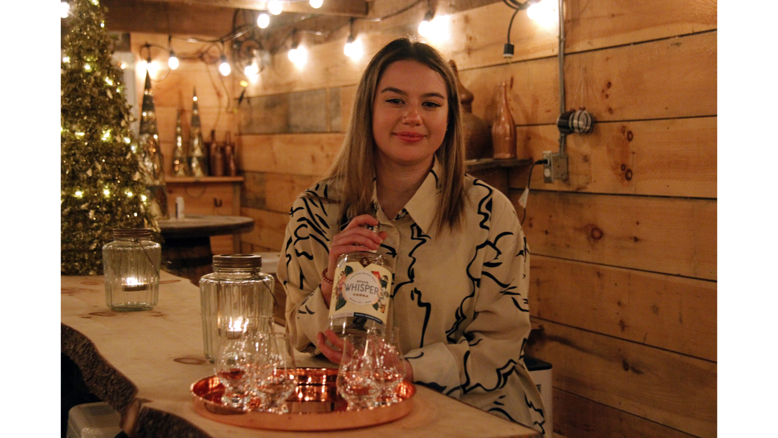 <p>Carley Wiwczaruk, employee at Kinsip House Of Fine Spirits, and  her first batch of triple distilled Still’s Whisper vodka. The Estate Vodka is available at the Bloomfield-area distillery. (Desirée Decoste/Gazette staff)</p>
