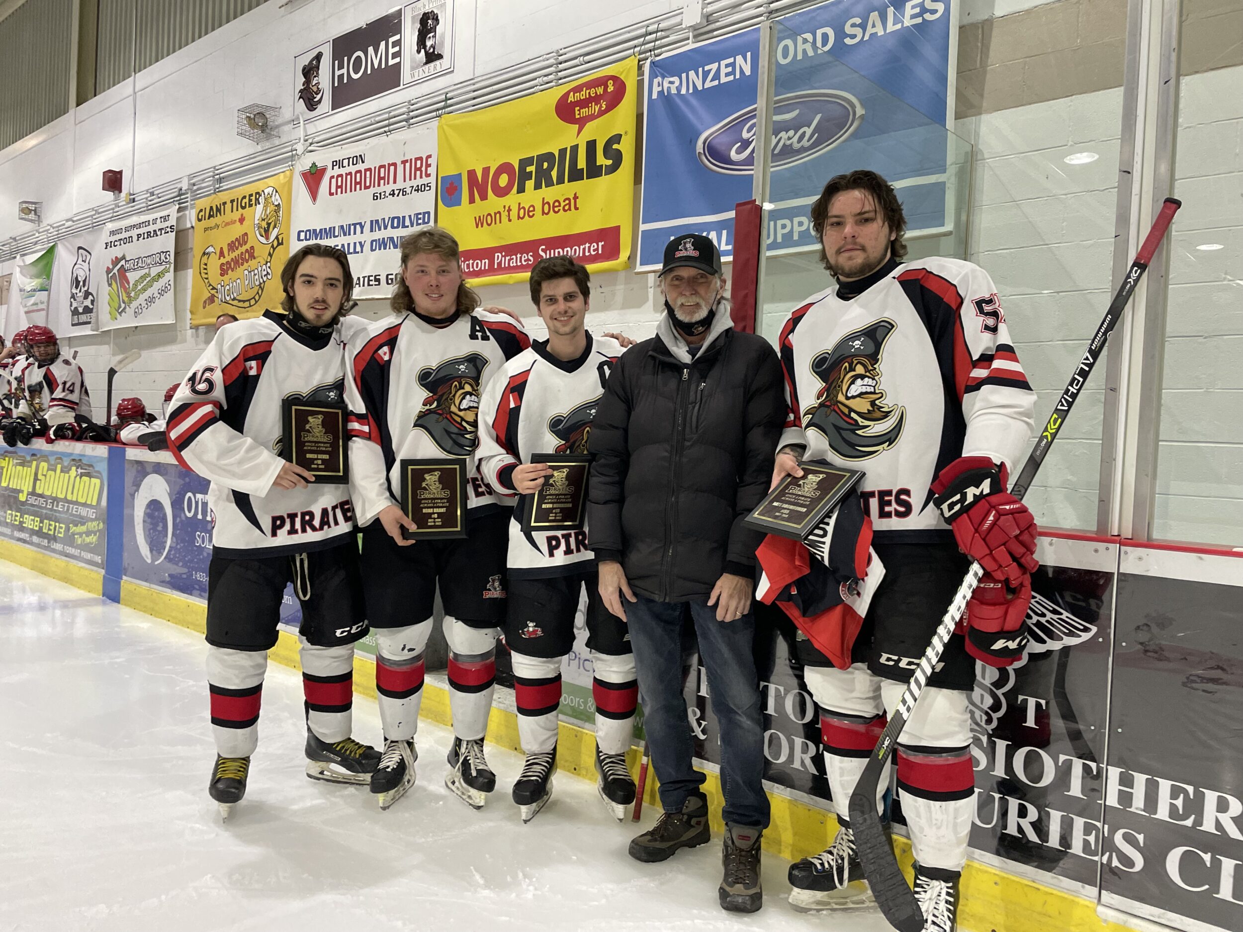 <p>Longtime Picton Pirates equipment manager Jack Broadbent presented 2022 graduates (From left) Owen Dever, Noah Brant, Devin Morrison and Nate Boomhower with plaques and commemorative jerseys Thursday night. (Submitted Photo)</p>
