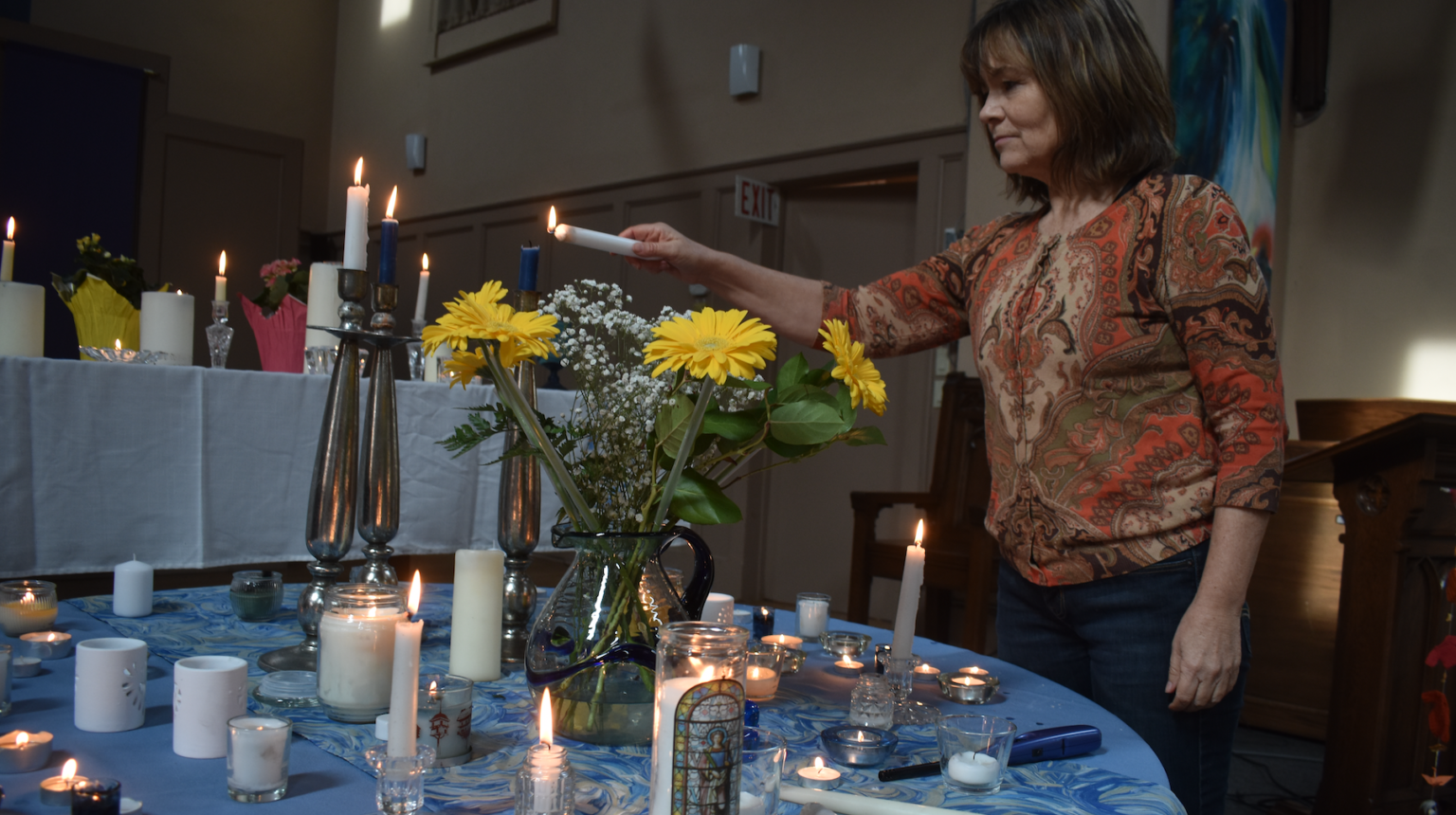 <p>St. Andrew’s Reverend Lynne Donovan lights a candle in solidarity with the people of Ukraine at a vigil held at the church Monday afternoon. (Jason Parks/Gazette Staff)</p>
