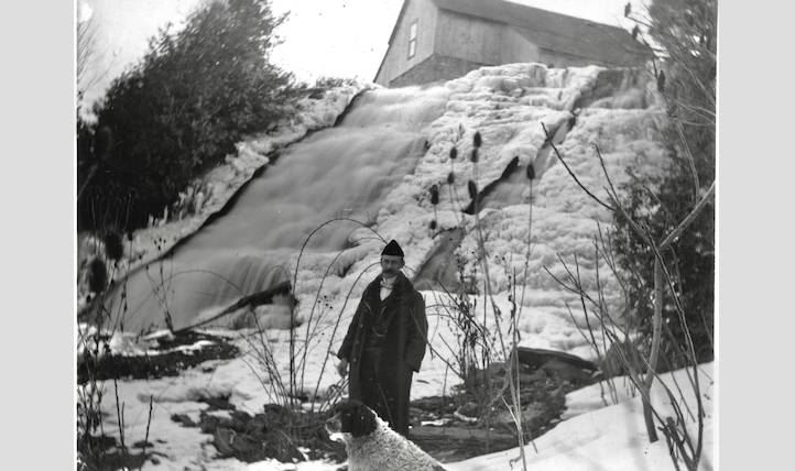 <p>A man and a dog in front of waterfalls at Hallowell Mills in this early 1900’s photo. (Marsden Kemp collection/Archives of Ontario)</p>
