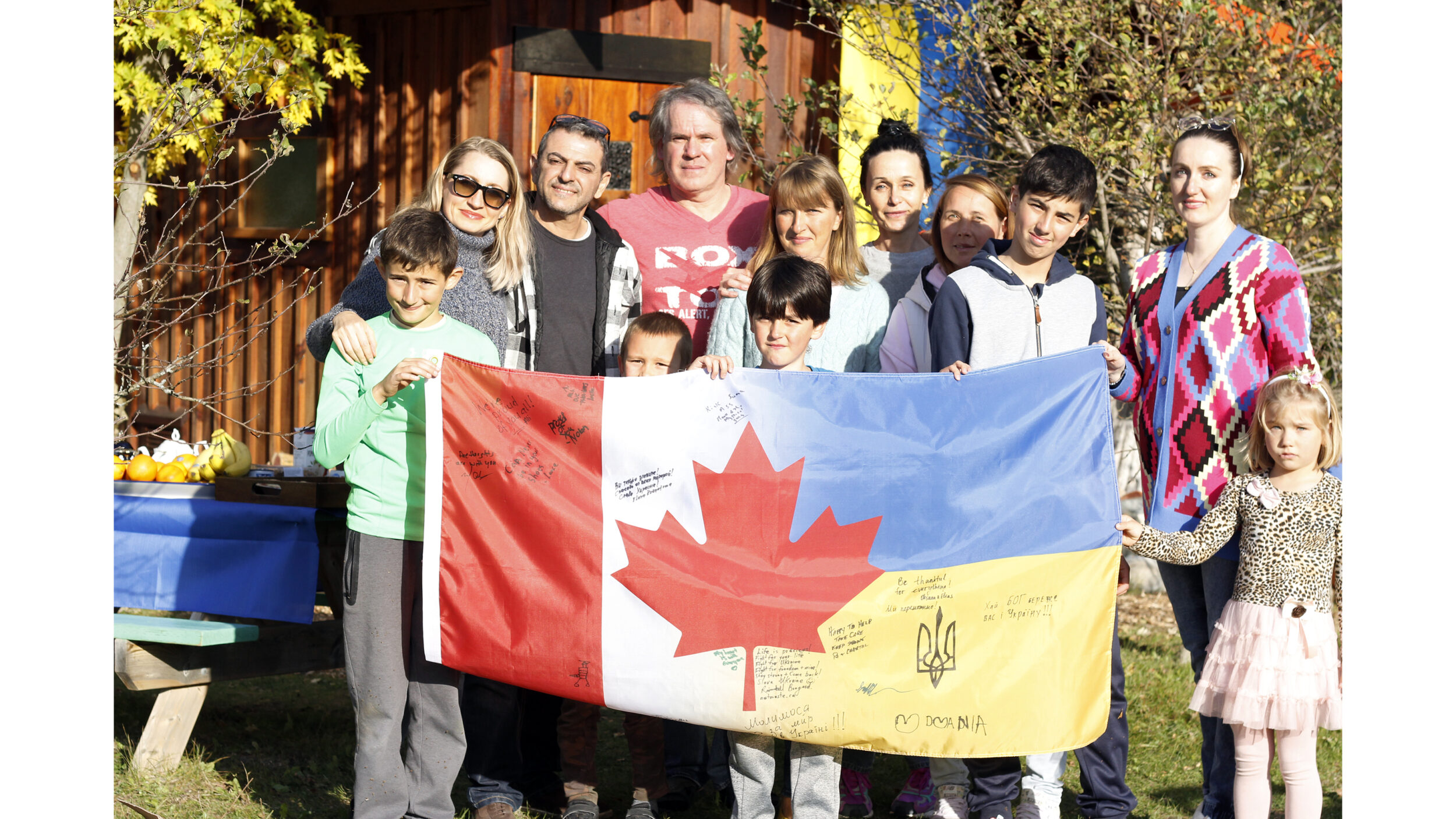 <p>Hosts Rivendell Bongard and Elena kuznetsova stood with invited Ukrainian families with the Canada-Ukrainian flag being sent to the front lines in Ukraine. (Desirée Decoste/Gazette staff)</p>
