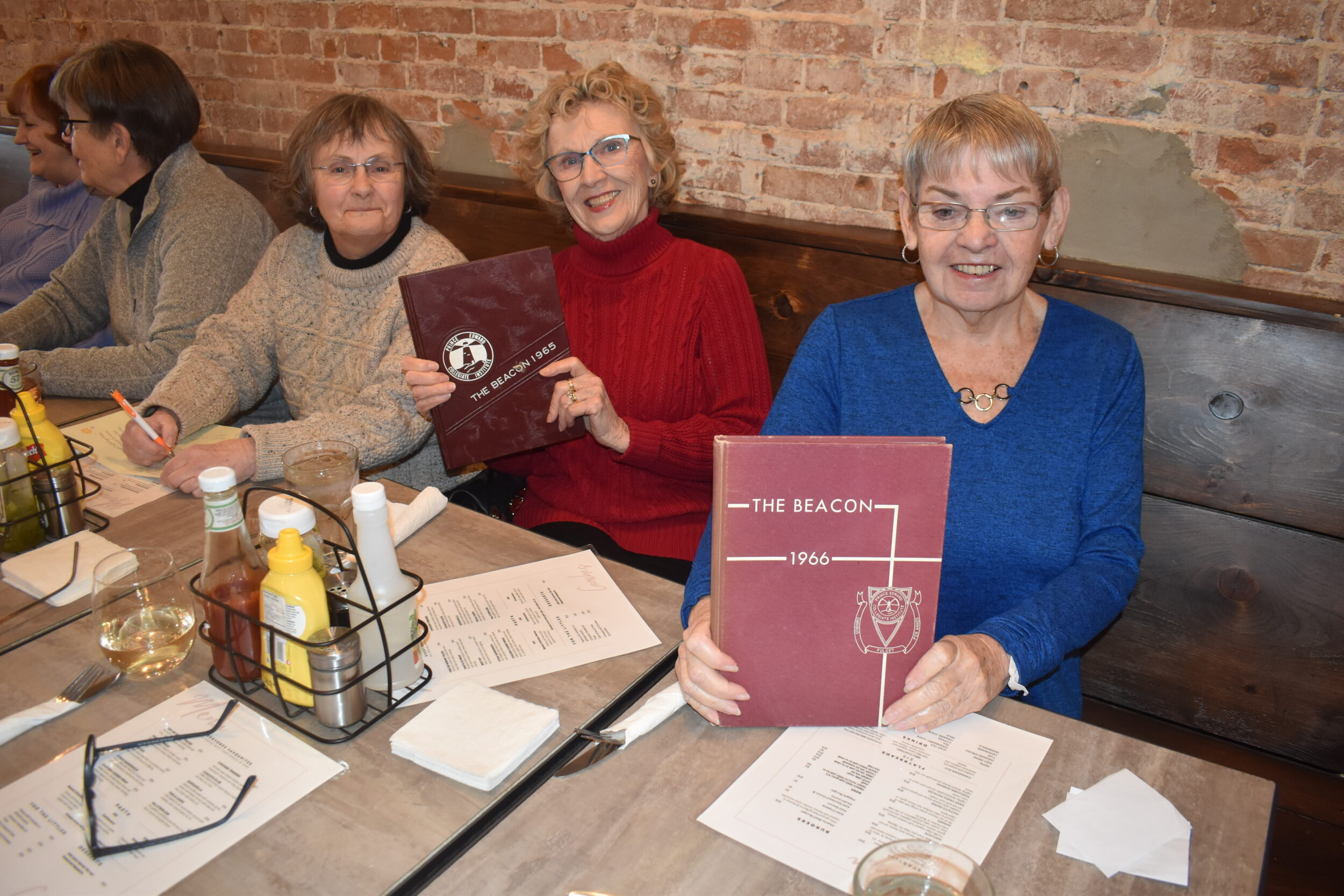 <p>IT SHINES THROUGHOUT THE YEARS- Jo Ann Ward, Christine Pearsoll and Sharon Coulter of PECI’s graduating class of 1966 display some copies of the Beacon at their recent luncheon at Coach’s Pub and Grillhouse. (Jason Parks/Gazette Staff) </p>
