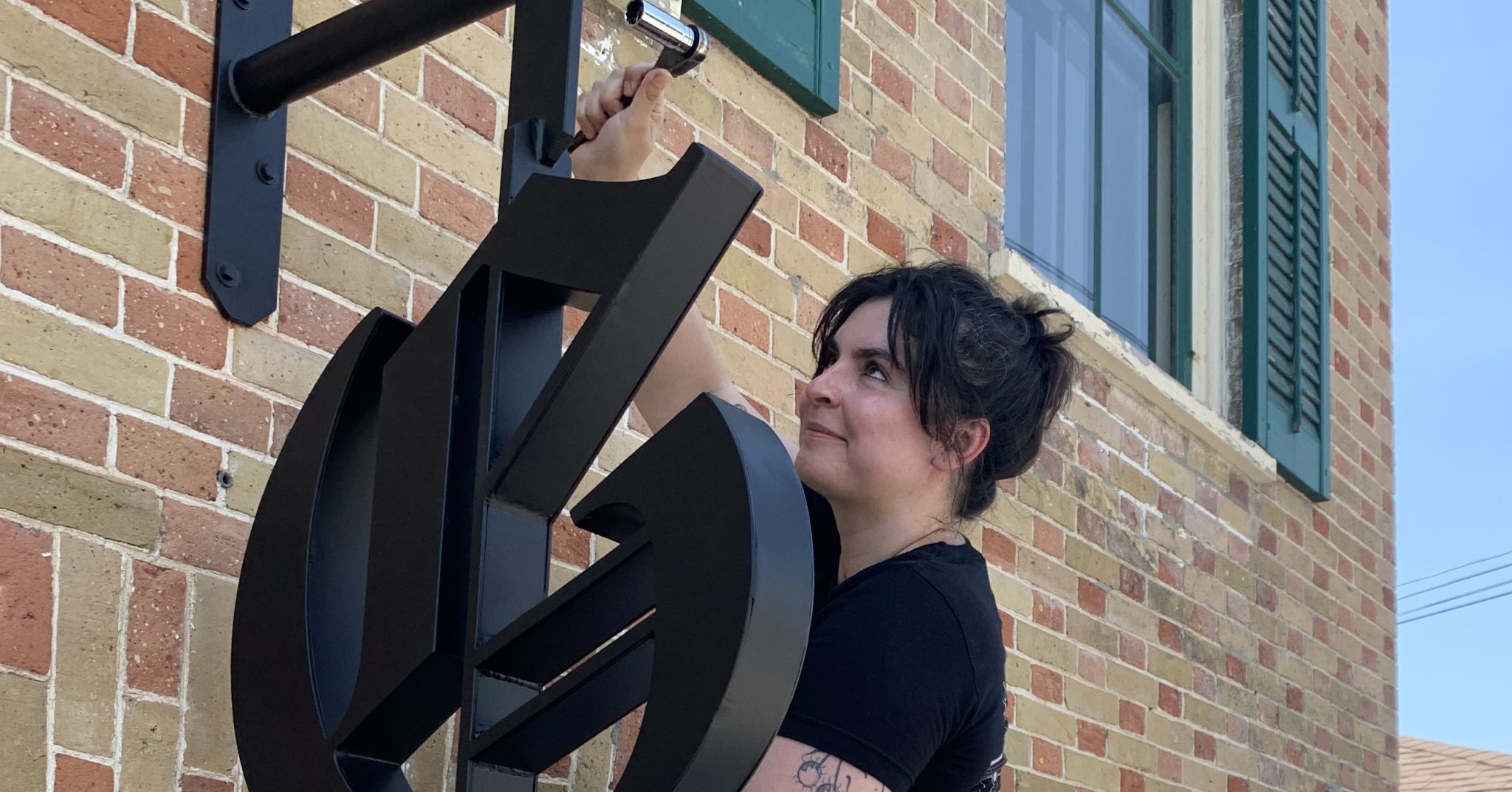 <p>Jill Botting of County Precision makes final adjustments to the new Gazette signage at 100 Main St. (Jason Parks/Gazette Staff)</p>
